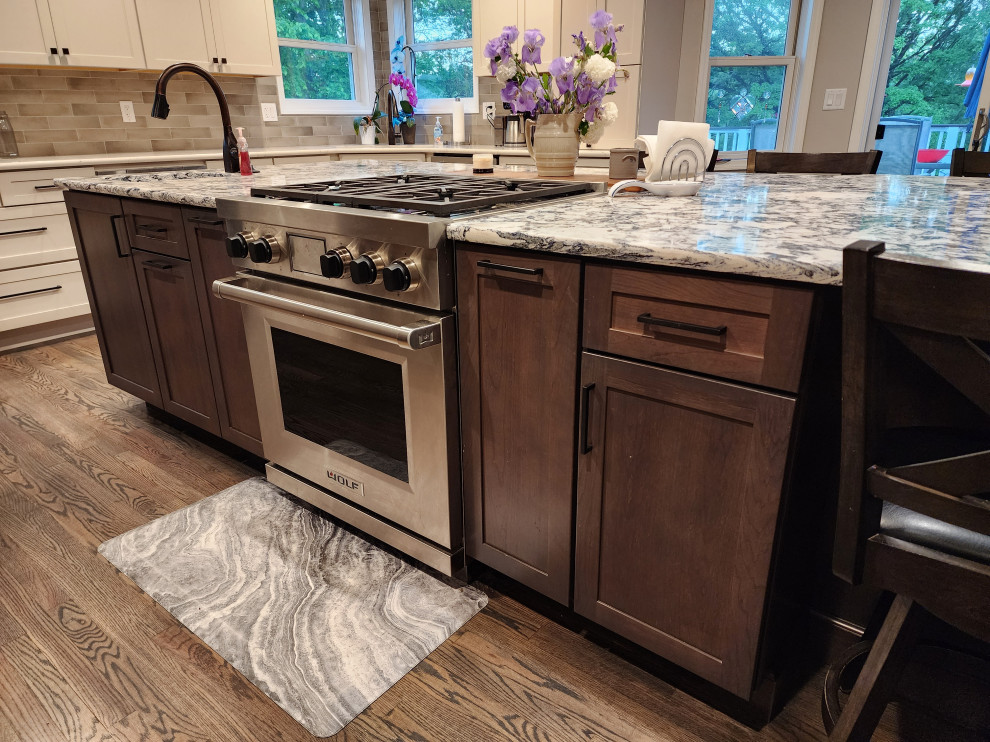 Eat-in kitchen - large farmhouse l-shaped medium tone wood floor and gray floor eat-in kitchen idea with an undermount sink, shaker cabinets, subway tile backsplash, stainless steel appliances, an island and multicolored countertops