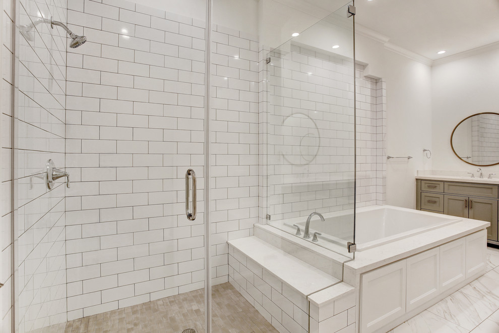 This is an example of a large traditional master bathroom in Houston with furniture-like cabinets, grey cabinets, a drop-in tub, a corner shower, a two-piece toilet, white tile, ceramic tile, white walls, porcelain floors, an undermount sink, engineered quartz benchtops, white floor, a hinged shower door and white benchtops.