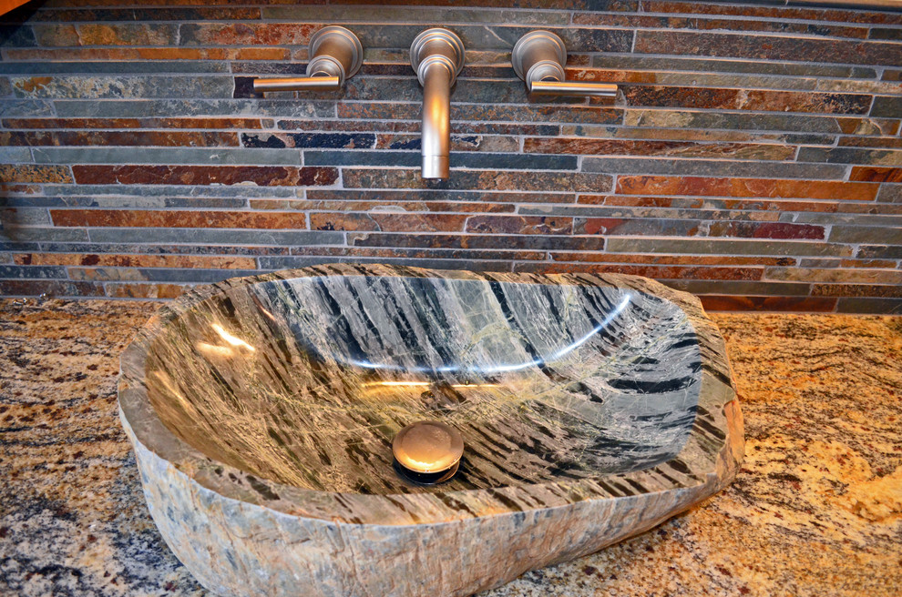 Transitional multicolored tile and stone tile doorless shower photo with a vessel sink, shaker cabinets, medium tone wood cabinets, granite countertops and a two-piece toilet