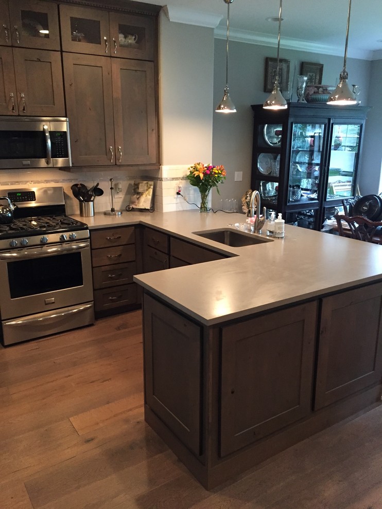 Large mountain style u-shaped linoleum floor eat-in kitchen photo in Denver with an undermount sink, shaker cabinets, medium tone wood cabinets, quartzite countertops, white backsplash, ceramic backsplash, stainless steel appliances and a peninsula