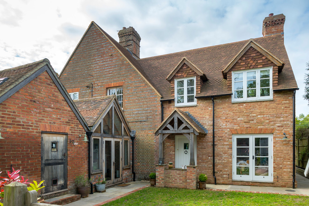 Mid-sized traditional two-storey brick brown duplex exterior in Kent with a gable roof and a tile roof.