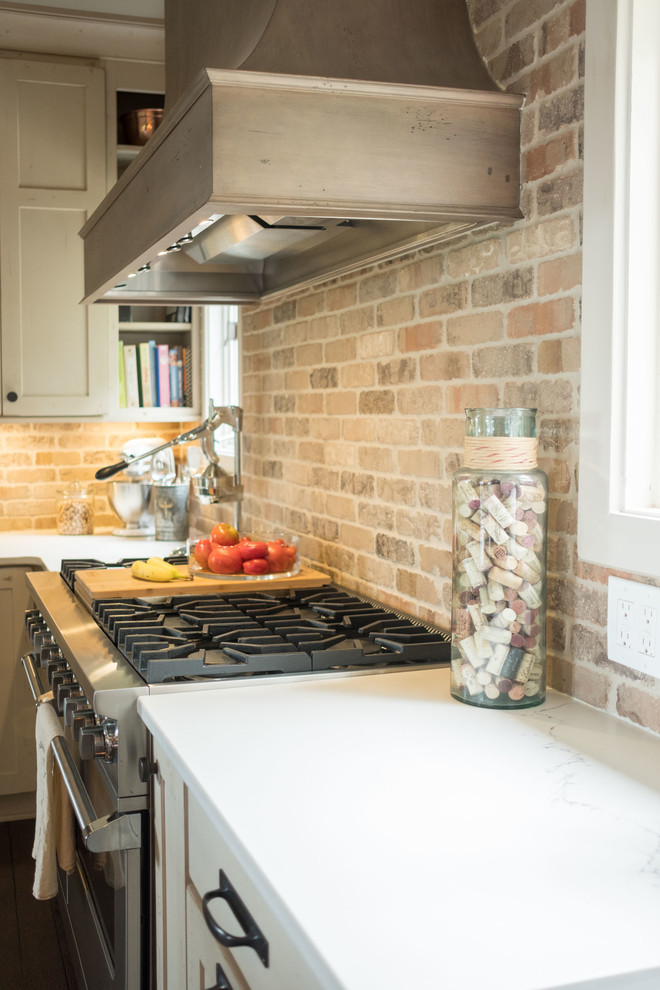 Example of a large transitional galley dark wood floor and brown floor open concept kitchen design with a farmhouse sink, shaker cabinets, quartz countertops, brown backsplash, brick backsplash, stainless steel appliances and an island