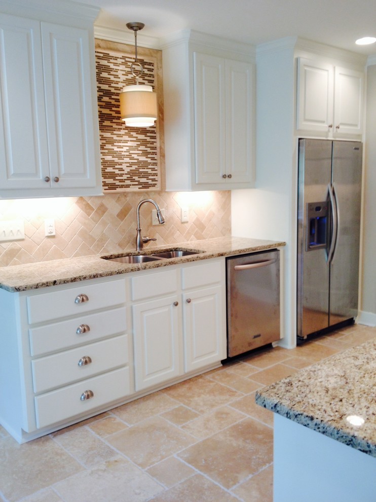 Mid-sized transitional galley ceramic tile and beige floor enclosed kitchen photo in Jackson with a double-bowl sink, raised-panel cabinets, white cabinets, granite countertops, brown backsplash, stainless steel appliances, no island and stone tile backsplash