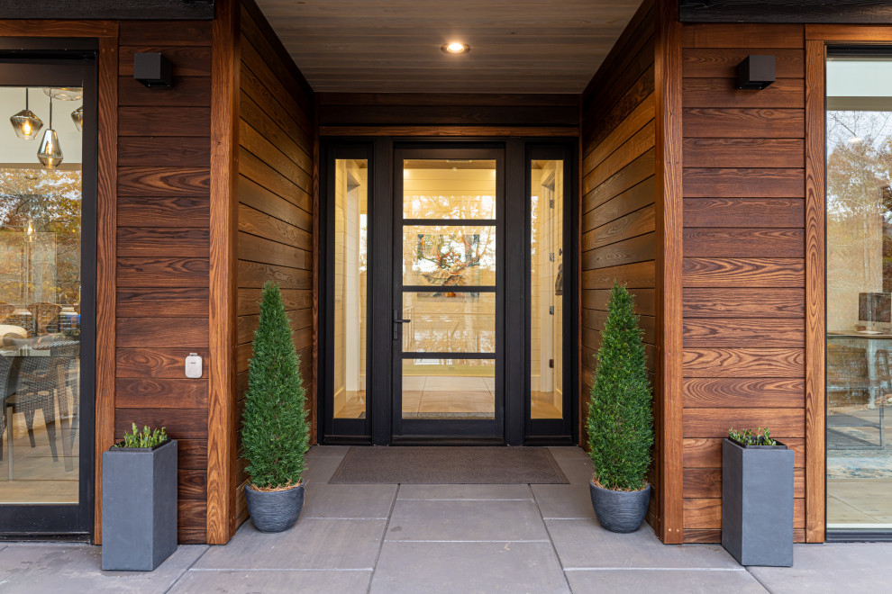 На фото: входная дверь среднего размера в стиле модернизм с бетонным полом, одностворчатой входной дверью, черной входной дверью, серым полом и деревянным потолком с
