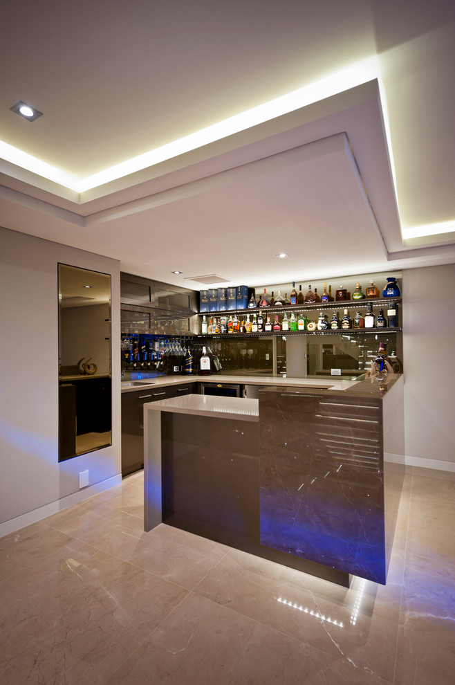 This is an example of a modern l-shaped home bar in Perth with an undermount sink, open cabinets, solid surface benchtops, ceramic floors, brown cabinets and mirror splashback.