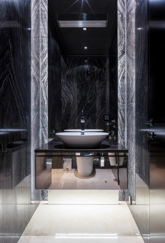 Photo of a small contemporary powder room in Moscow with flat-panel cabinets, black cabinets, gray tile, marble, marble floors, marble benchtops, beige floor, black benchtops and a vessel sink.