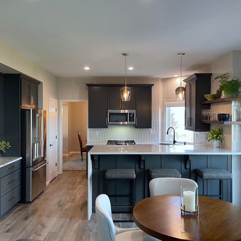 Example of a transitional porcelain tile and brown floor kitchen design in Denver with an undermount sink, quartzite countertops, gray backsplash, porcelain backsplash, stainless steel appliances and white countertops