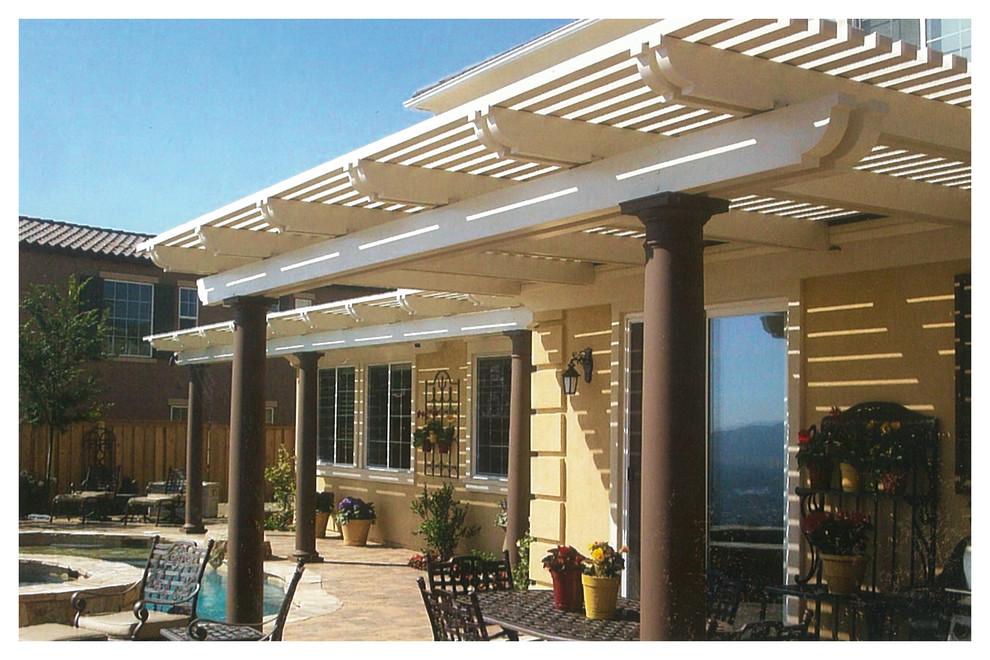 This is an example of a mid-sized traditional backyard patio in Orange County with concrete pavers and a pergola.