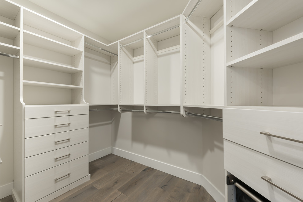 Inspiration for a large transitional gender-neutral walk-in wardrobe in Seattle with open cabinets, white cabinets, medium hardwood floors and brown floor.