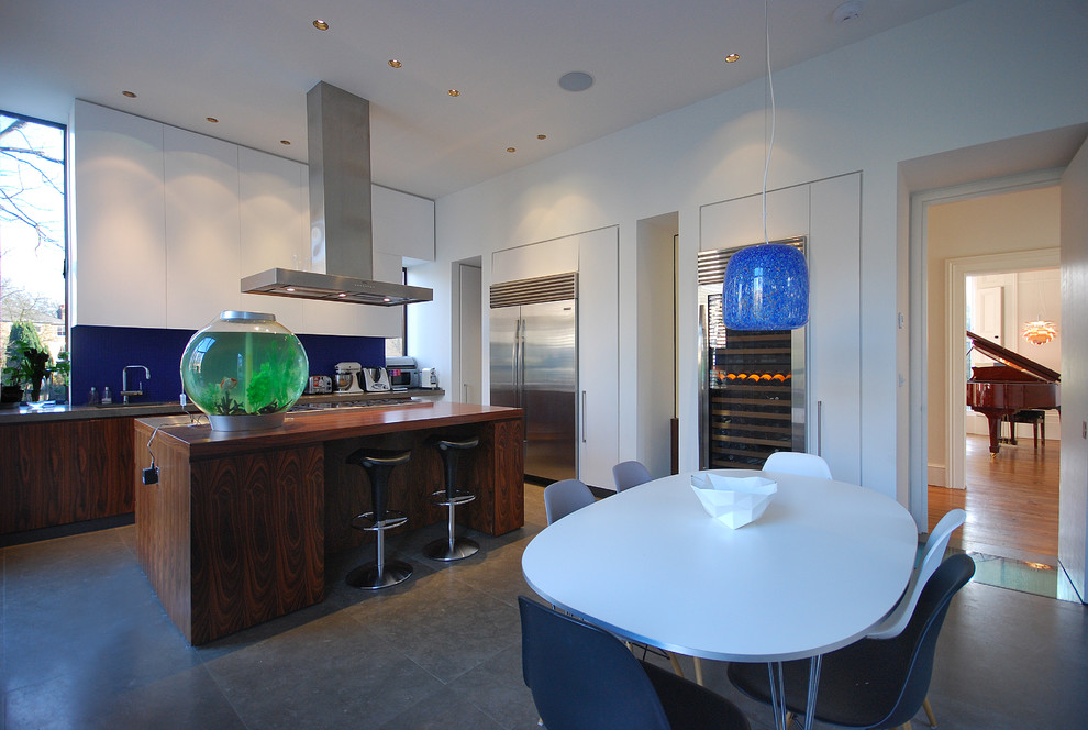 Large contemporary single-wall eat-in kitchen in London with a double-bowl sink, flat-panel cabinets, dark wood cabinets, stainless steel benchtops, blue splashback, ceramic splashback, stainless steel appliances, limestone floors and with island.