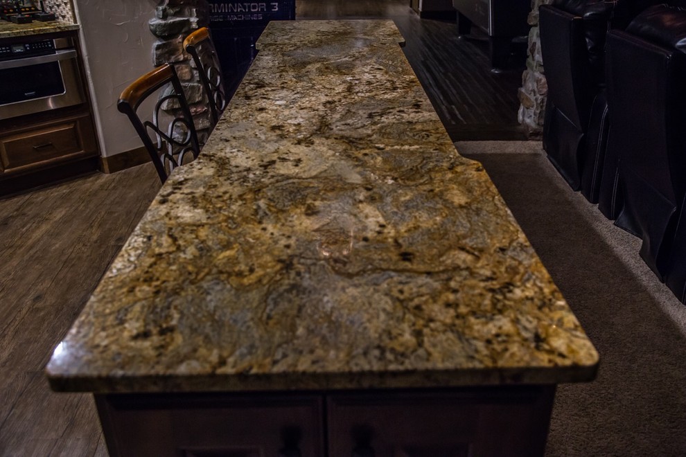Home bar - large traditional single-wall dark wood floor and brown floor home bar idea in Denver with raised-panel cabinets, dark wood cabinets, granite countertops, beige backsplash and stone tile backsplash