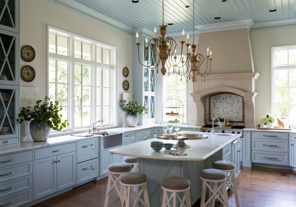 Design ideas for a traditional u-shaped kitchen in Other with a farmhouse sink, recessed-panel cabinets, blue cabinets, medium hardwood floors, with island and brown floor.