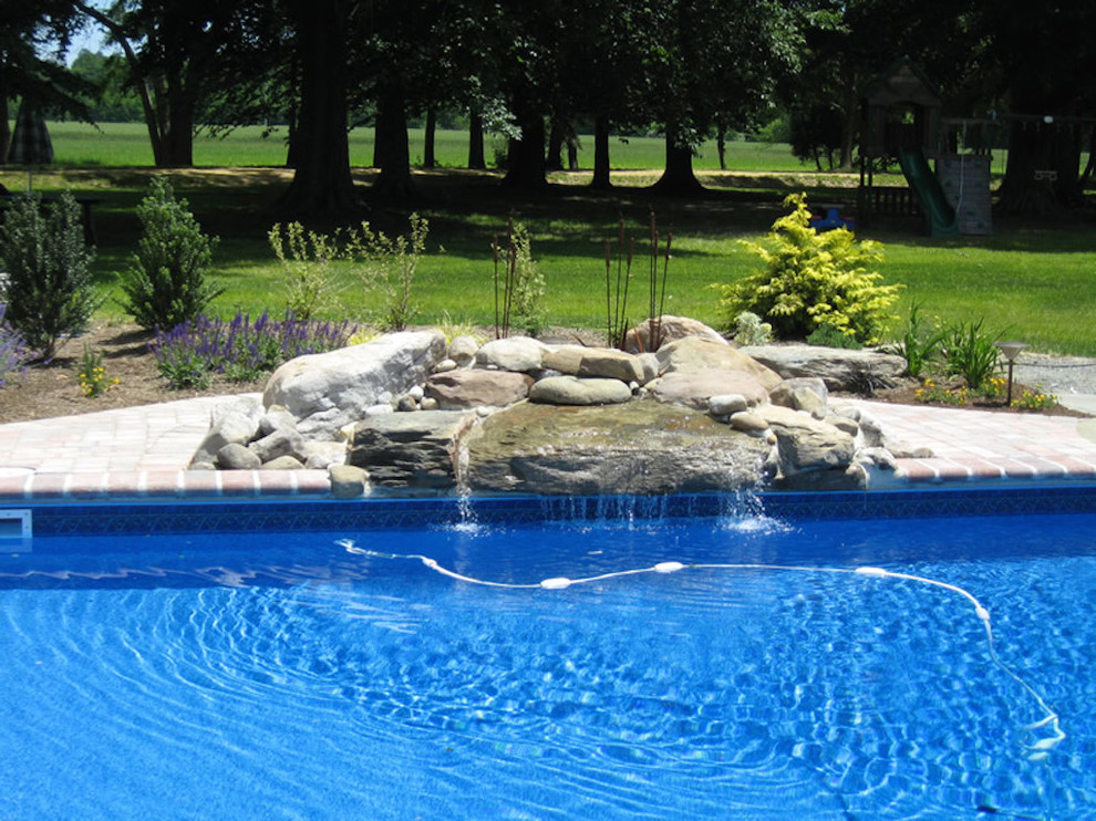 Mid-sized transitional backyard brick and rectangular lap pool fountain photo in Baltimore