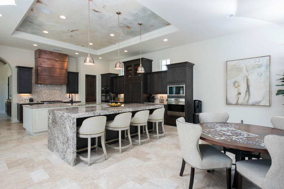 Design ideas for a transitional l-shaped eat-in kitchen in Orlando with an undermount sink, recessed-panel cabinets, black cabinets, grey splashback, panelled appliances, multiple islands, beige floor and grey benchtop.