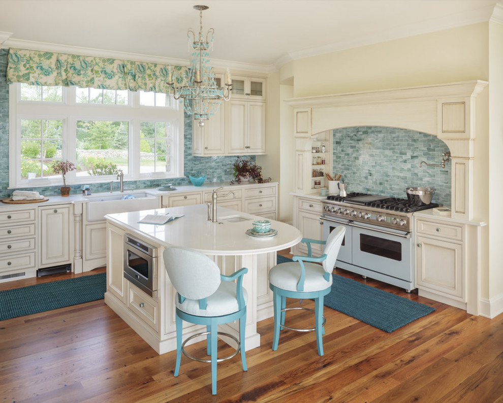Beach style l-shaped kitchen in Portland Maine with a farmhouse sink, recessed-panel cabinets, beige cabinets, blue splashback, coloured appliances, medium hardwood floors and with island.