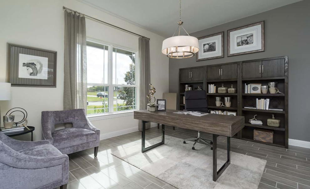 This is an example of a contemporary study in Houston with ceramic flooring, a freestanding desk and grey floors.