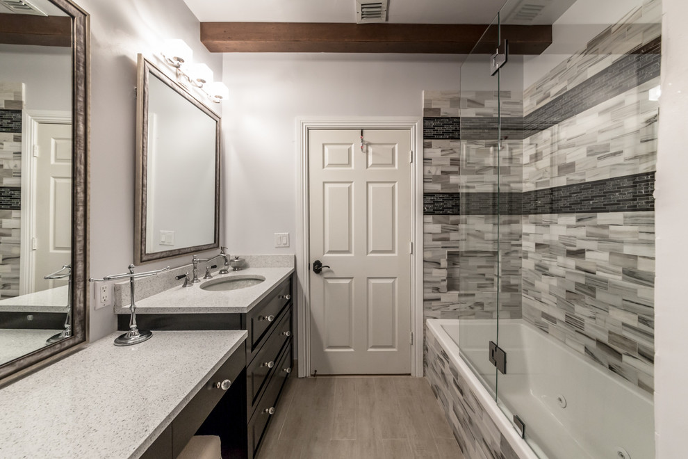 Photo of a mid-sized contemporary master bathroom in Miami with raised-panel cabinets, dark wood cabinets, a drop-in tub, an alcove shower, a two-piece toilet, black tile, black and white tile, gray tile, matchstick tile, grey walls, porcelain floors, an undermount sink and engineered quartz benchtops.