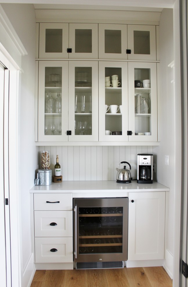 Inspiration for a large transitional l-shaped eat-in kitchen remodel in Toronto with an undermount sink, shaker cabinets, white cabinets, quartz countertops, white backsplash, stainless steel appliances and an island