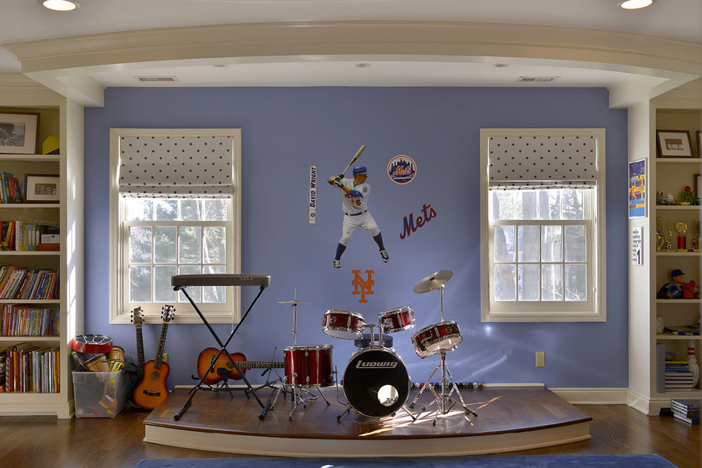 This is an example of a large transitional kids' playroom for kids 4-10 years old and boys in New York with blue walls and medium hardwood floors.