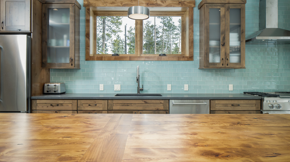 Mid-sized mountain style single-wall eat-in kitchen photo in Denver with an undermount sink, shaker cabinets, distressed cabinets, quartz countertops, blue backsplash, glass tile backsplash, stainless steel appliances, an island and gray countertops