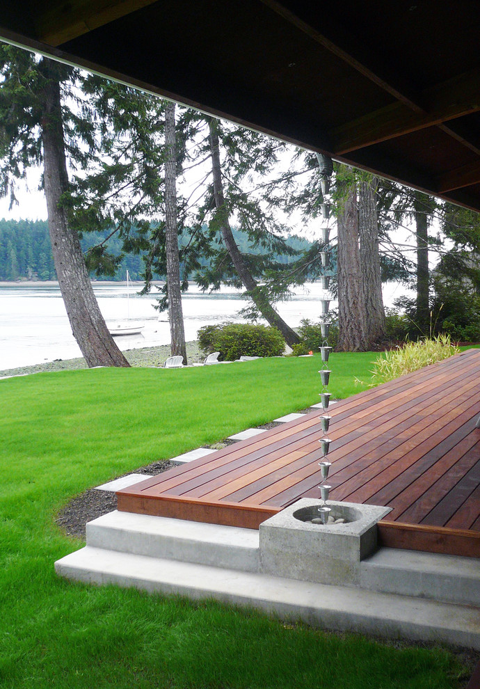 Inspiration for a mid-sized contemporary backyard deck in Seattle with a water feature and a roof extension.