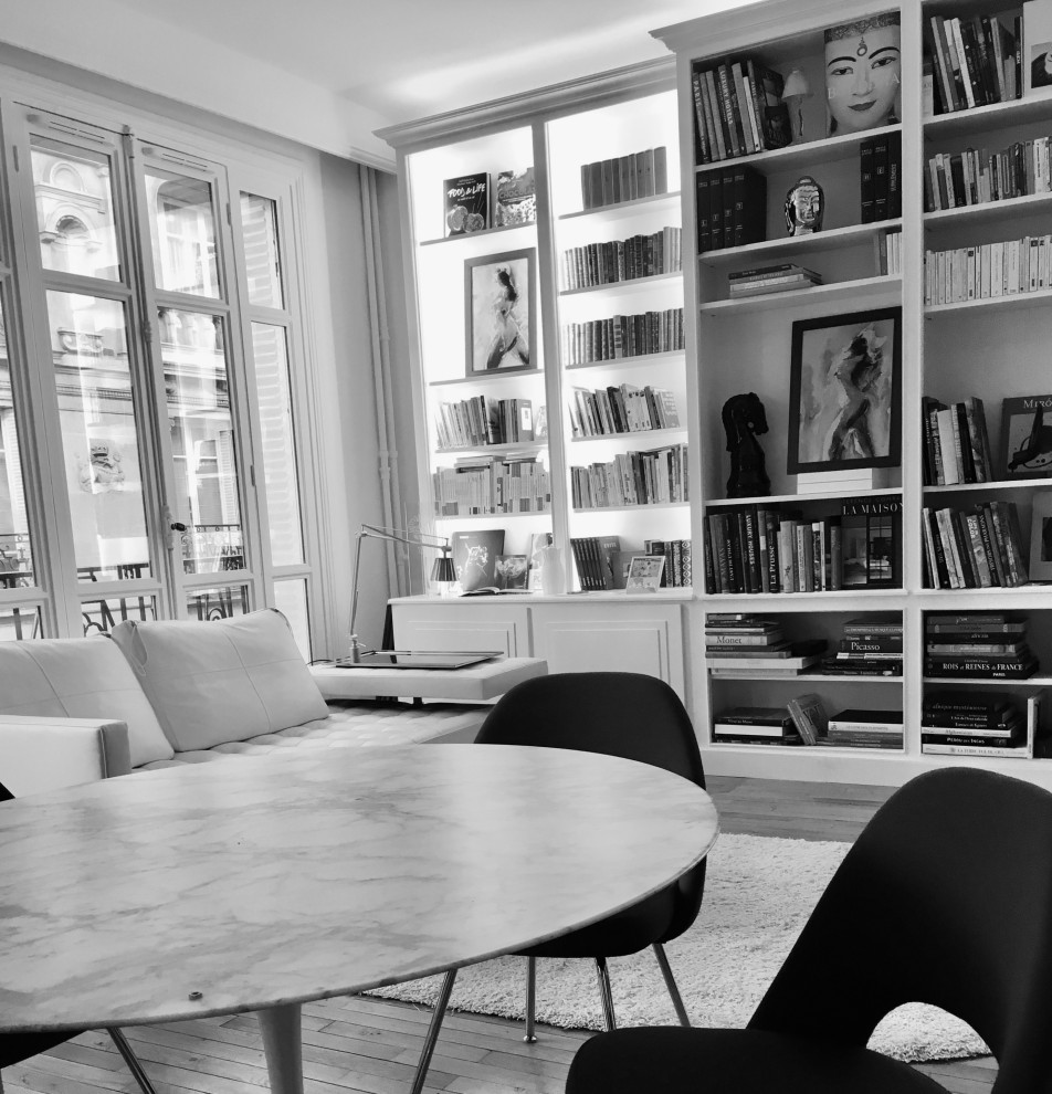Ispirazione per un grande soggiorno minimal aperto con libreria, pareti bianche, parquet chiaro, nessuna TV e pavimento beige
