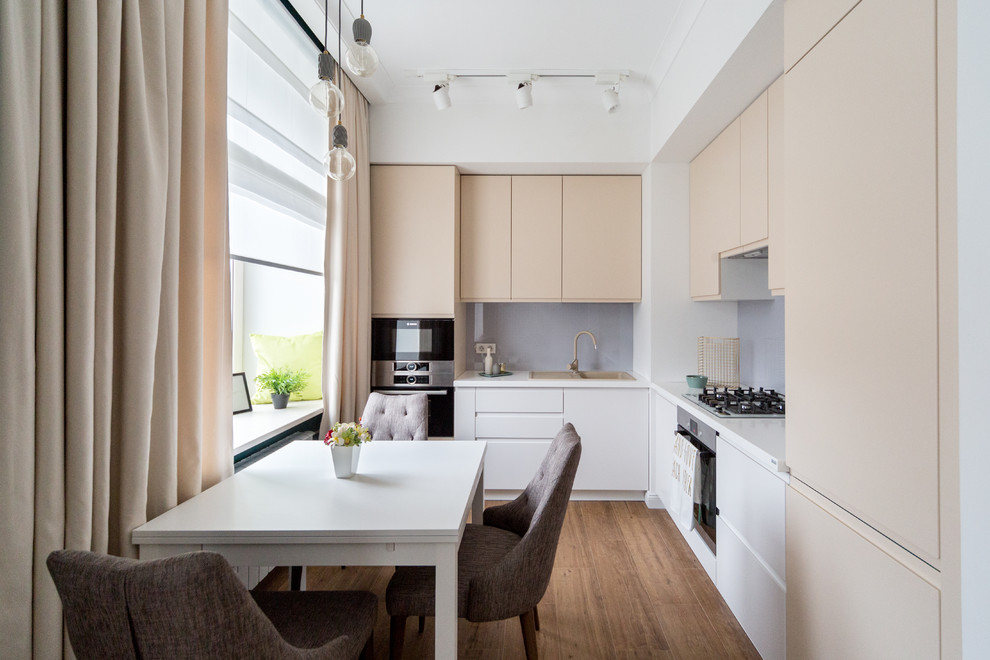 This is an example of a contemporary l-shaped open plan kitchen in Moscow with a drop-in sink, flat-panel cabinets, grey splashback, black appliances and no island.