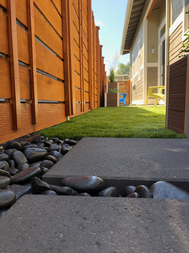 Idee per un piccolo giardino xeriscape moderno stretto e esposto in pieno sole nel cortile laterale in estate con pavimentazioni in cemento e recinzione in legno