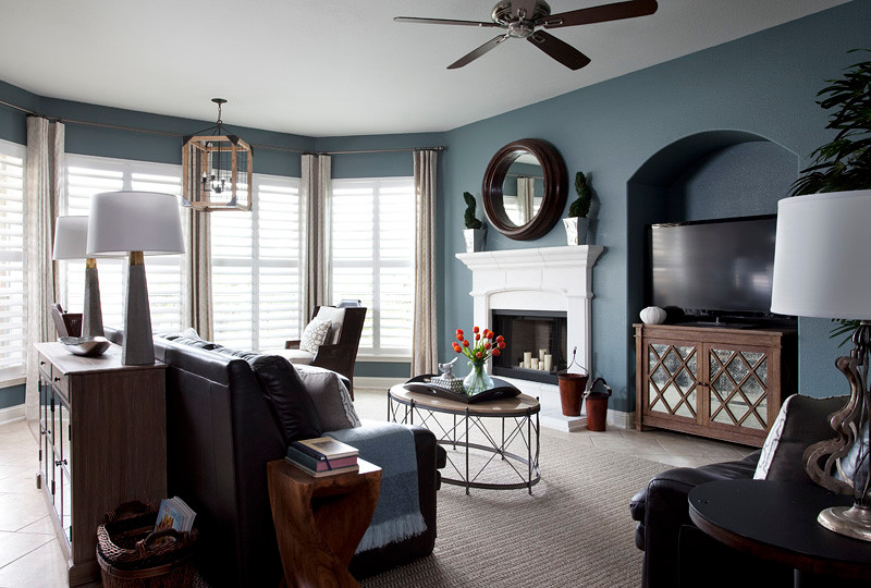 Photo of a transitional living room in Austin with blue walls, a standard fireplace and a freestanding tv.