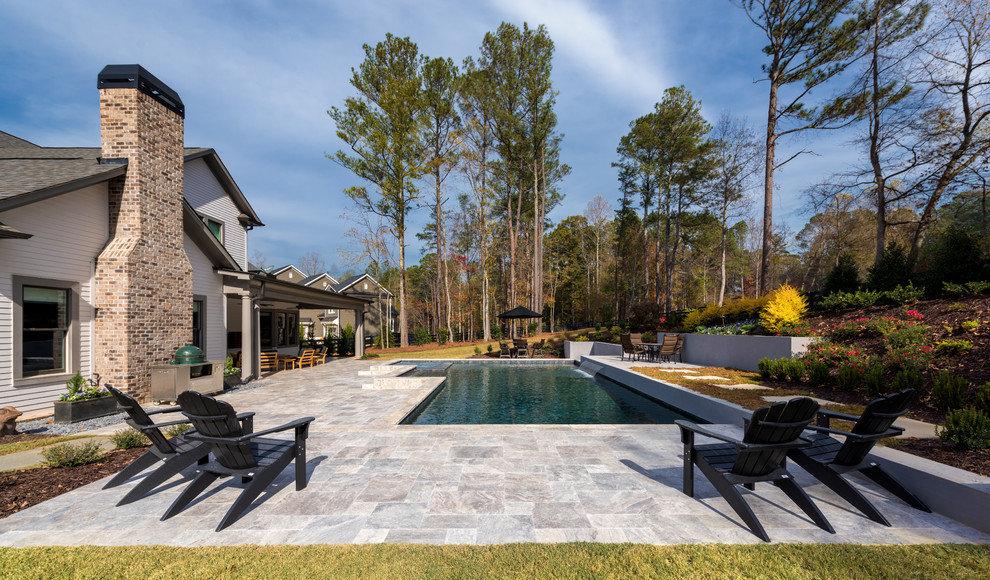 Mid-sized traditional backyard custom-shaped pool in Atlanta with a water feature and natural stone pavers.