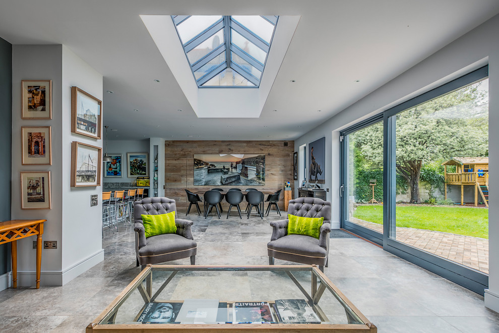 Mid-sized contemporary open concept living room in Dublin with grey walls and grey floor.