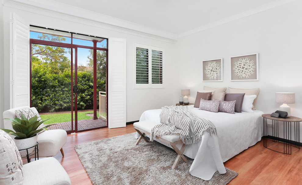 Mid-sized transitional master bedroom in Sydney with white walls, light hardwood floors and orange floor.