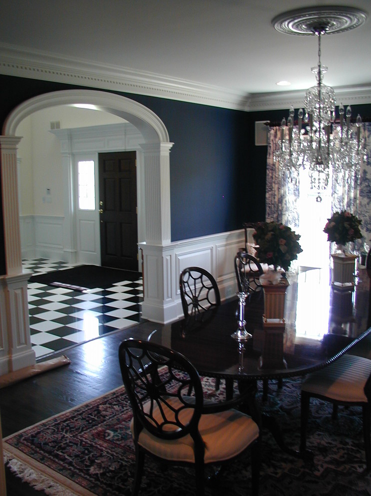 Large traditional separate dining room in New York with blue walls, dark hardwood floors and no fireplace.
