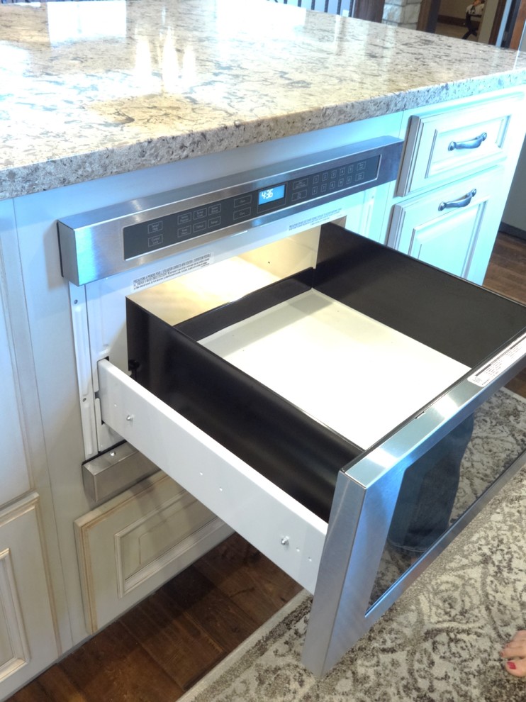 Open concept kitchen - large single-wall open concept kitchen idea with an undermount sink, raised-panel cabinets, medium tone wood cabinets, quartzite countertops, stainless steel appliances and an island