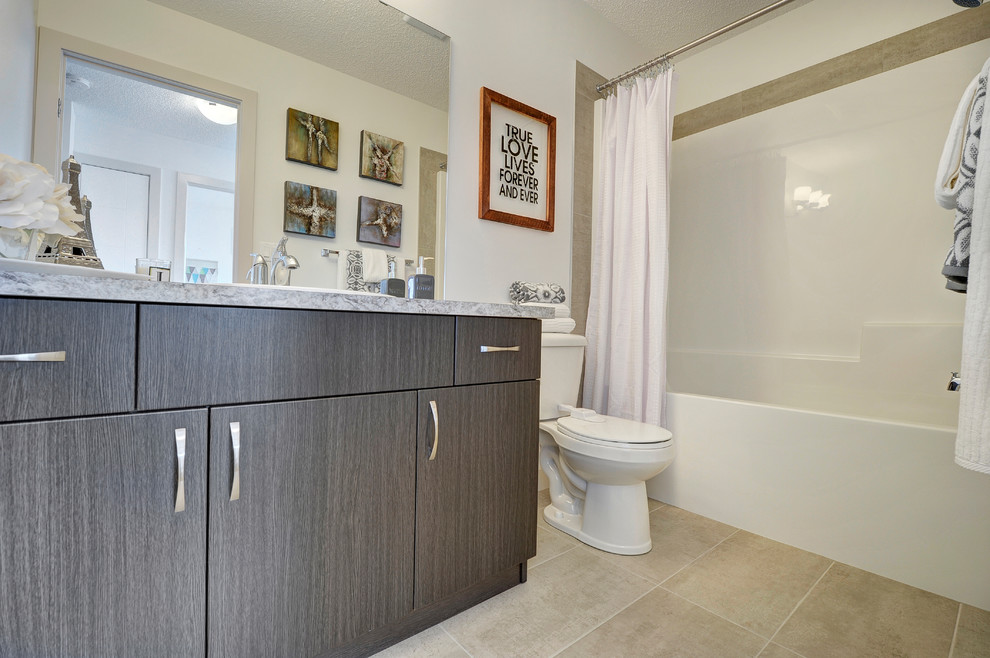 Inspiration for a mid-sized transitional kids' white tile and ceramic tile ceramic tile and beige floor alcove bathtub remodel in Edmonton with flat-panel cabinets, black cabinets, a two-piece toilet, white walls, a drop-in sink and laminate countertops