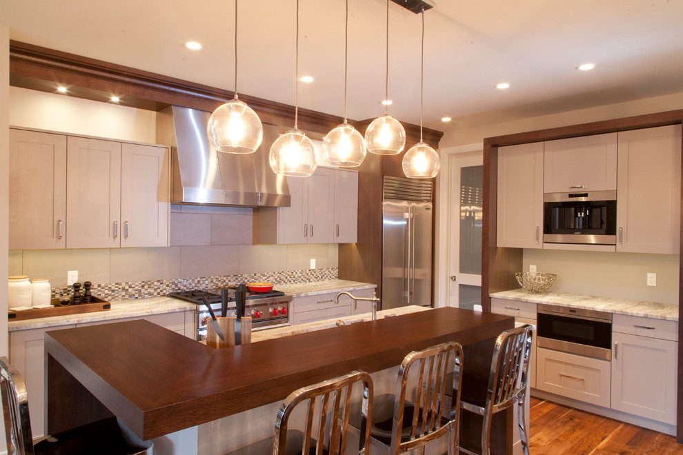 Example of a mid-sized transitional l-shaped dark wood floor eat-in kitchen design in Calgary with beige cabinets, stainless steel appliances and an island