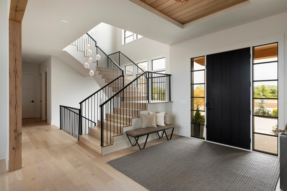 Design ideas for a transitional entryway in Minneapolis with white walls, light hardwood floors, a single front door, a black front door and timber.