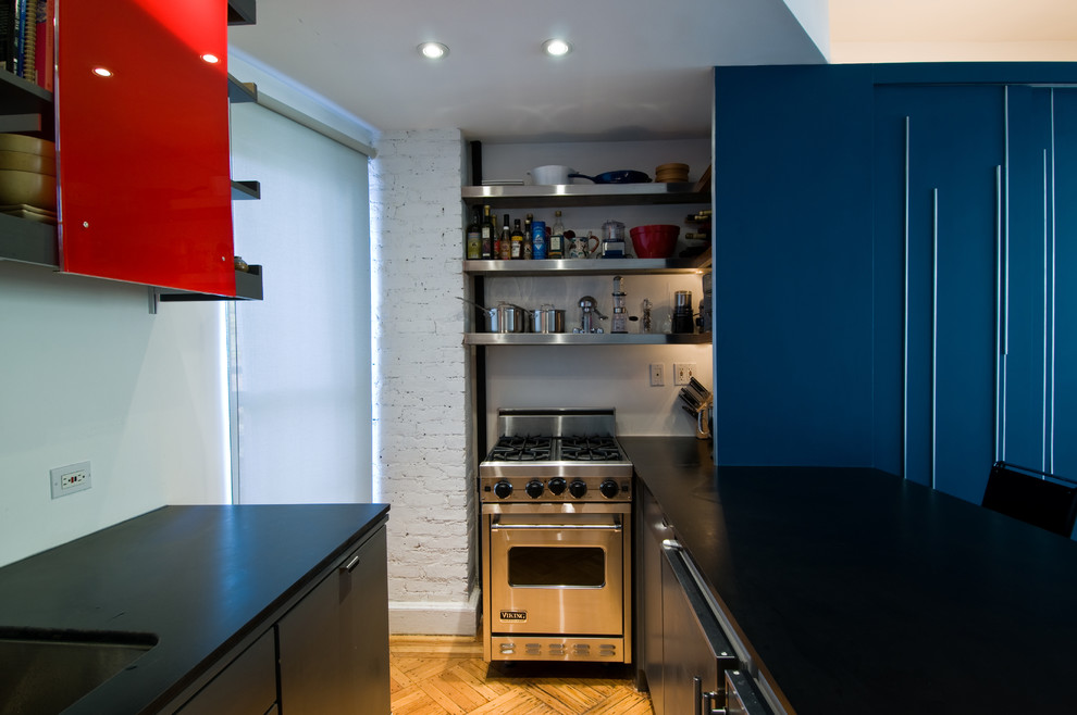 Photo of a modern open plan kitchen in New York with stainless steel appliances, an undermount sink, flat-panel cabinets and blue cabinets.