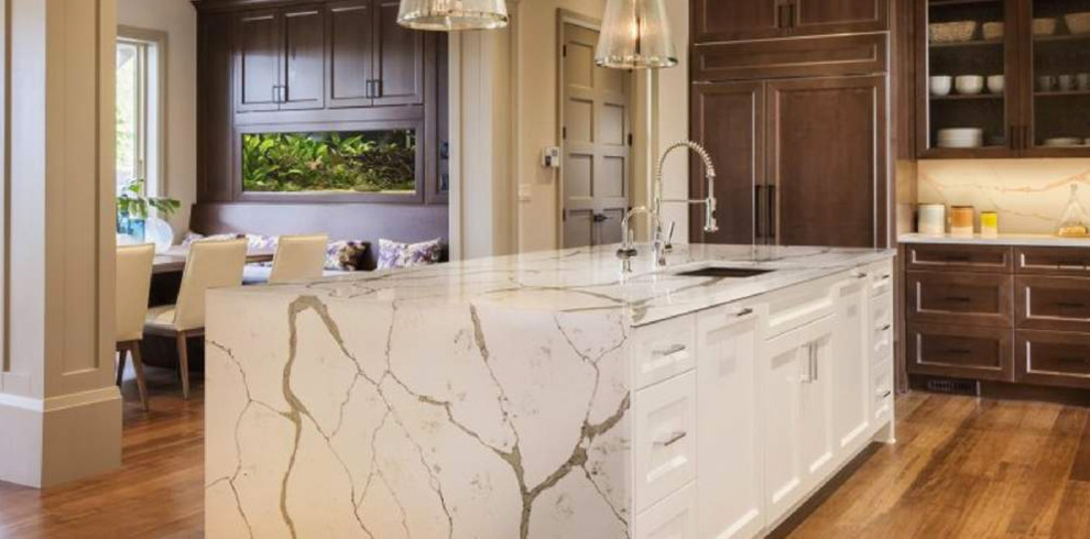 Eat-in kitchen - large transitional l-shaped medium tone wood floor and brown floor eat-in kitchen idea with an undermount sink, recessed-panel cabinets, dark wood cabinets, quartzite countertops, white backsplash, stone slab backsplash, paneled appliances and an island