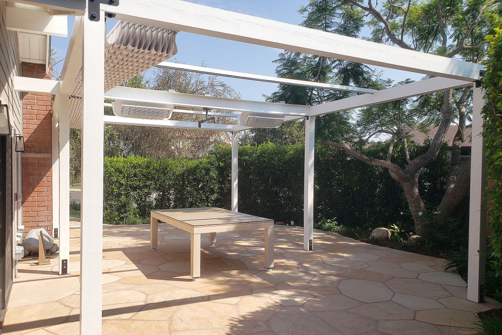 Inspiration for a medium sized contemporary back patio in Santa Barbara with natural stone paving and a pergola.
