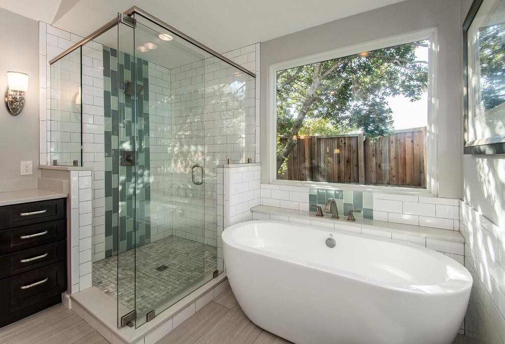 This is an example of a mid-sized contemporary master bathroom in Los Angeles with shaker cabinets, dark wood cabinets, a curbless shower, a one-piece toilet, multi-coloured tile, porcelain tile, beige walls, plywood floors, an integrated sink, solid surface benchtops, beige floor, a sliding shower screen and white benchtops.