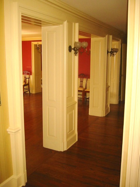 Example of a large country medium tone wood floor hallway design in New York with red walls