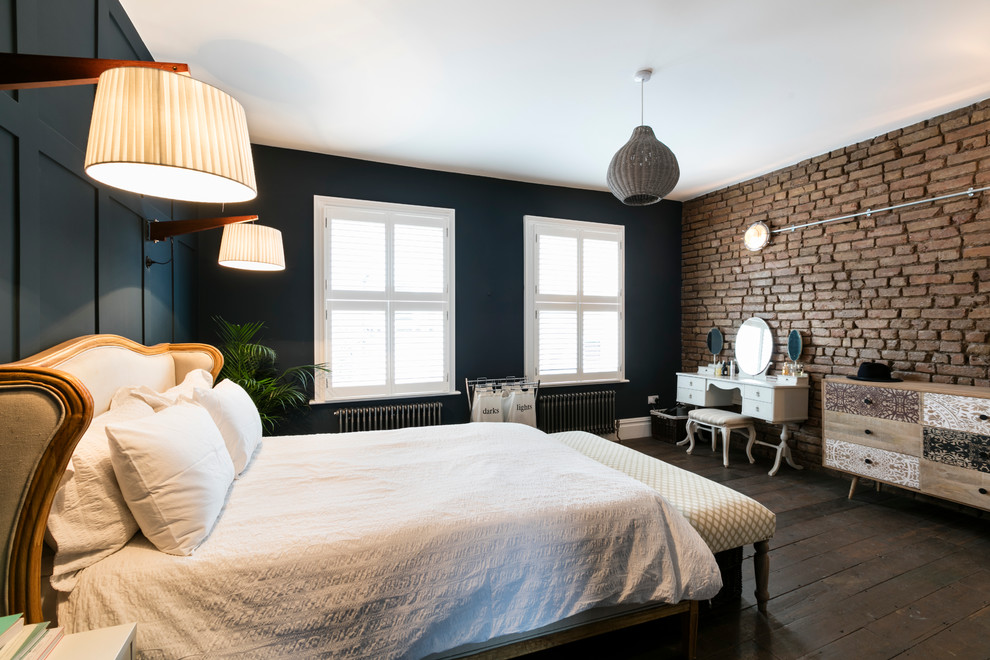 Photo of a transitional master bedroom in London with dark hardwood floors and blue walls.