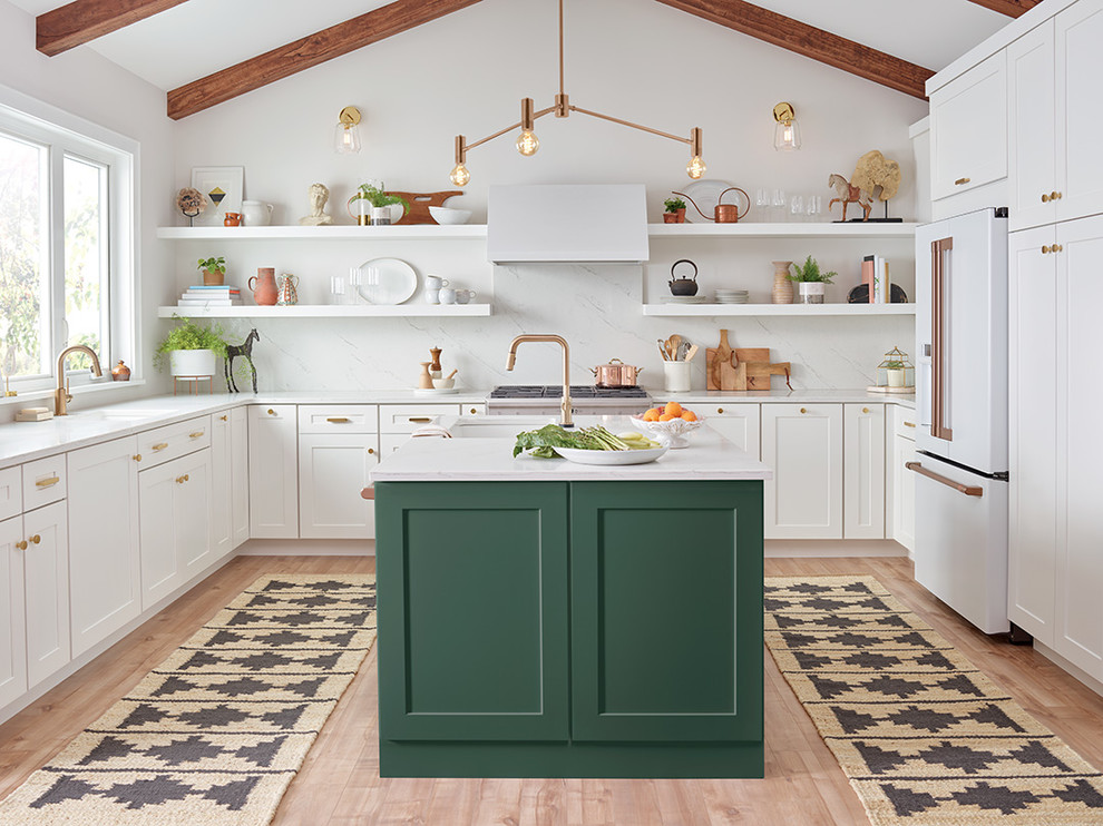 Design ideas for a transitional u-shaped kitchen in Portland with white cabinets, marble benchtops, white splashback, marble splashback, white appliances, light hardwood floors, white benchtop, an undermount sink, shaker cabinets, with island and beige floor.
