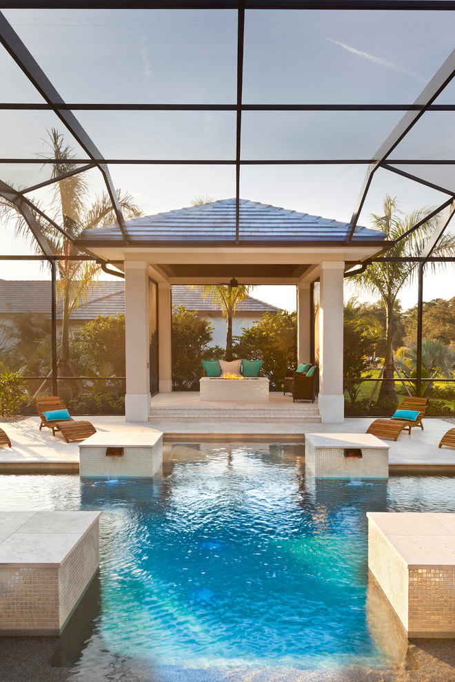 Inspiration for an expansive tropical custom-shaped pool in Tampa with natural stone pavers.