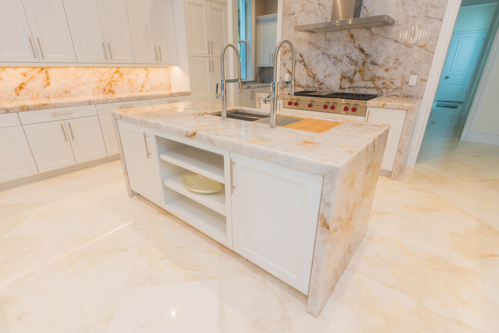 Huge transitional u-shaped marble floor and white floor open concept kitchen photo with an undermount sink, flat-panel cabinets, white cabinets, quartzite countertops, white backsplash, stone slab backsplash and two islands