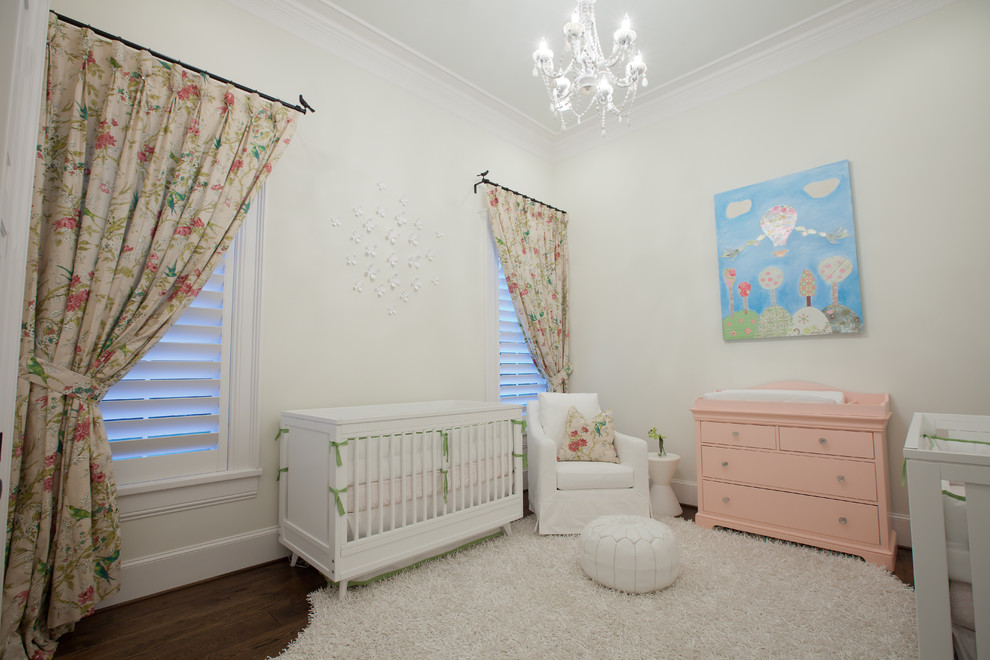Photo of a traditional nursery for girls in Dallas with white walls and dark hardwood floors.