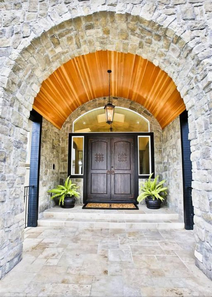 Example of a huge tuscan travertine floor and beige floor entryway design in San Francisco with beige walls