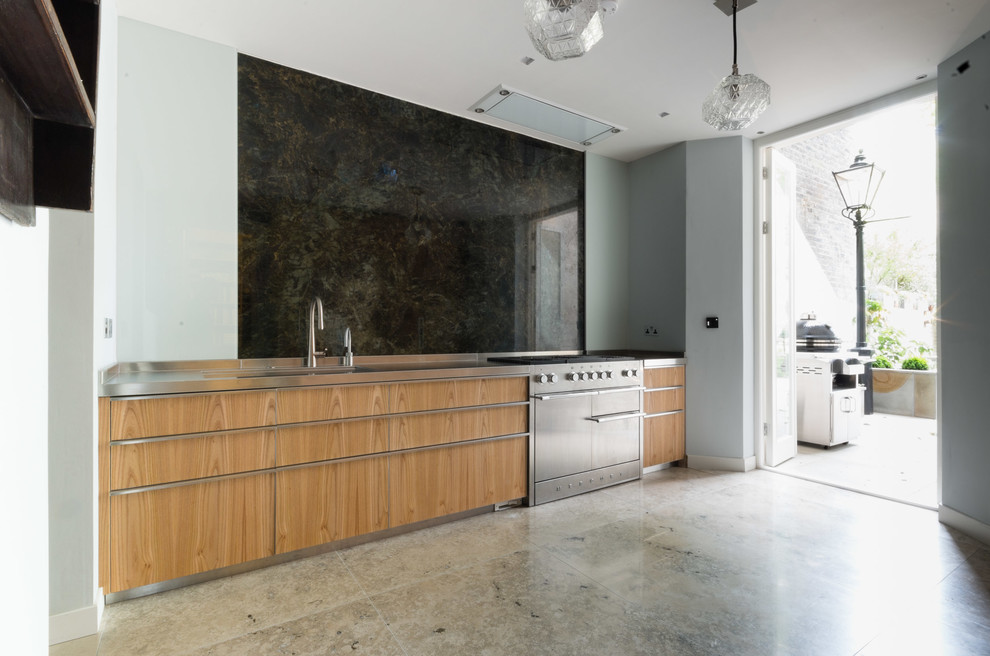 Mid-sized contemporary galley separate kitchen in London with an integrated sink, flat-panel cabinets, medium wood cabinets, stainless steel benchtops, black splashback, stone slab splashback, stainless steel appliances, marble floors and no island.