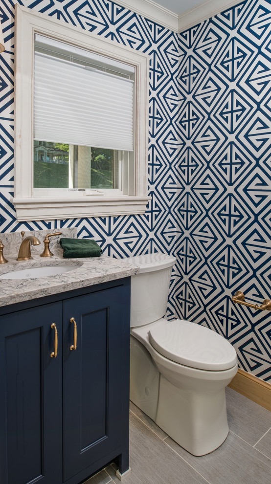 Design ideas for a small beach style powder room in Other with recessed-panel cabinets, blue cabinets, a two-piece toilet, multi-coloured walls, porcelain floors, an undermount sink, grey floor, granite benchtops and grey benchtops.